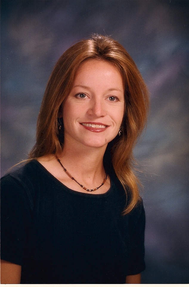 Professional woman smiling in a studio portrait.