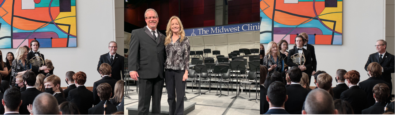 Two people standing in front of a stage with The Midwest Clinic banner.